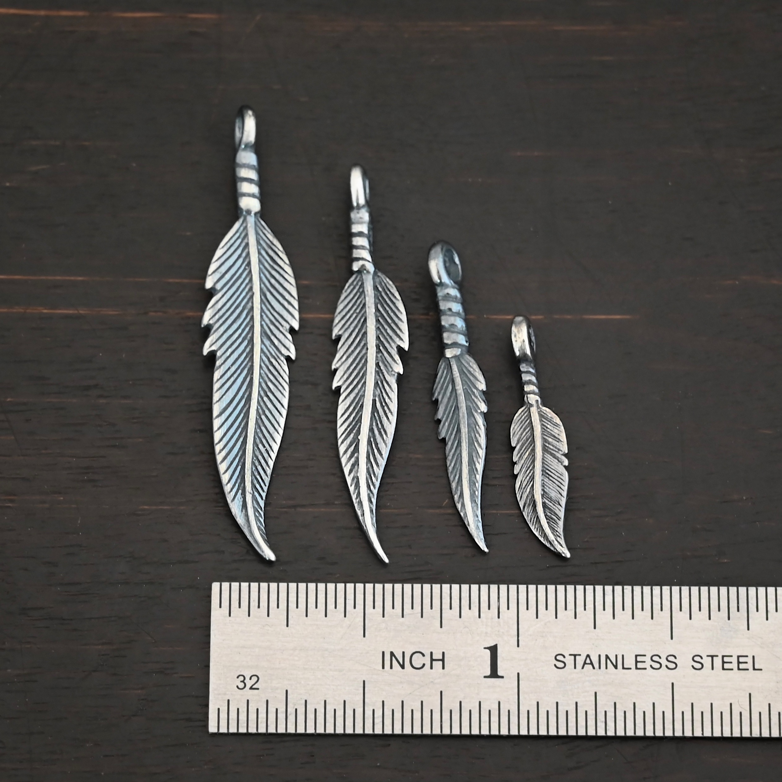 Silver oxidized double sided feather charms all sizes shown by ruler
