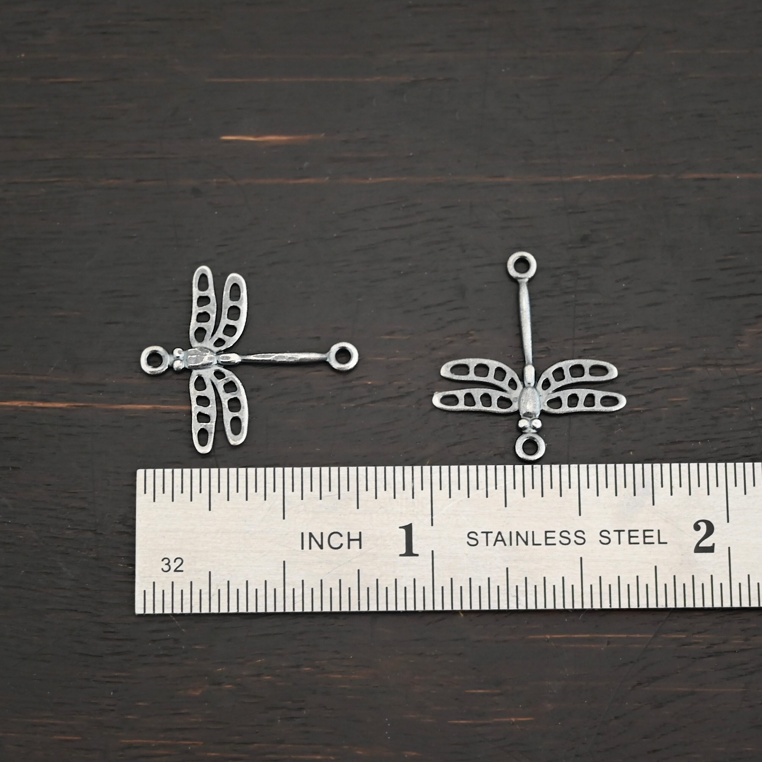 Silver oxidized dragonfly charms shown by ruler