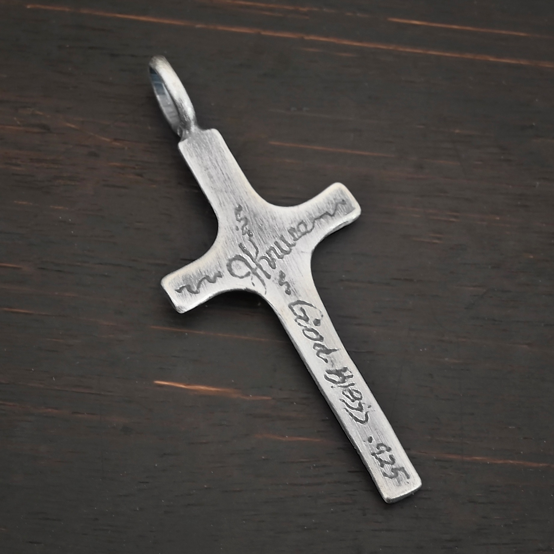 Back side of Silver large Cross pendant oxidized shown on dark background