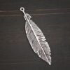 Silver Feather charm oxidized charm shown on dark background