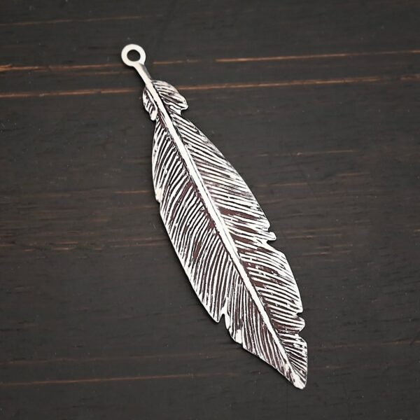 Silver Feather charm oxidized charm shown on dark background