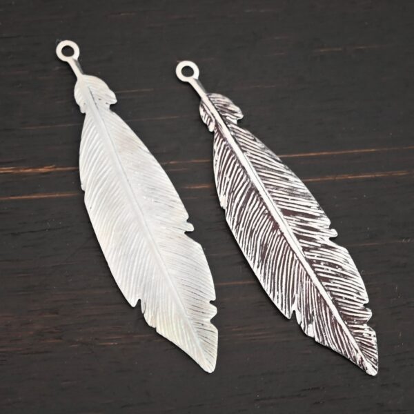 Silver Feather charm shiny & oxidized charm shown on dark background