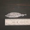 Silver Feather charm oxidized charm shown by ruler