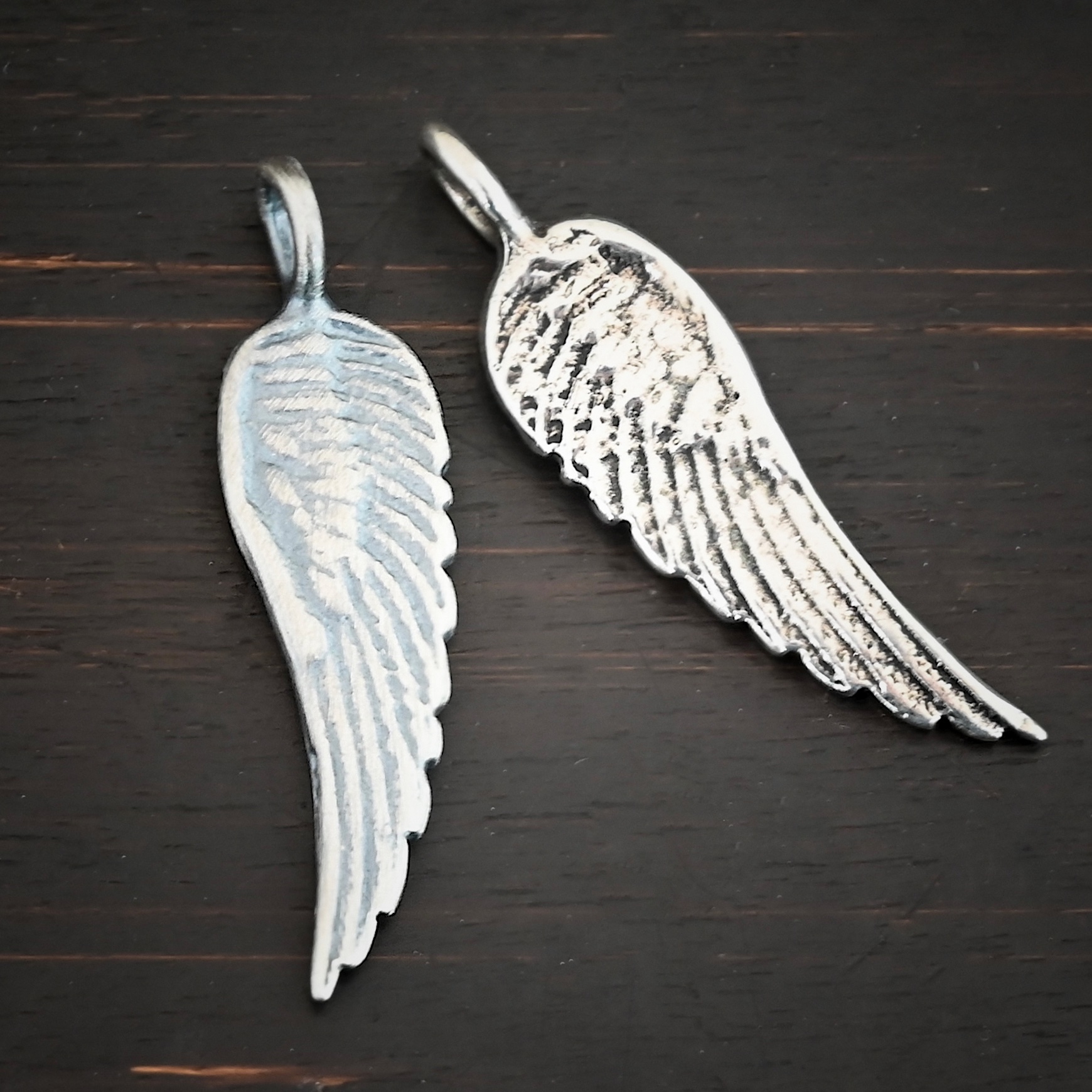 Silver Angel Wing charm oxidized & shiny charm shown on dark background