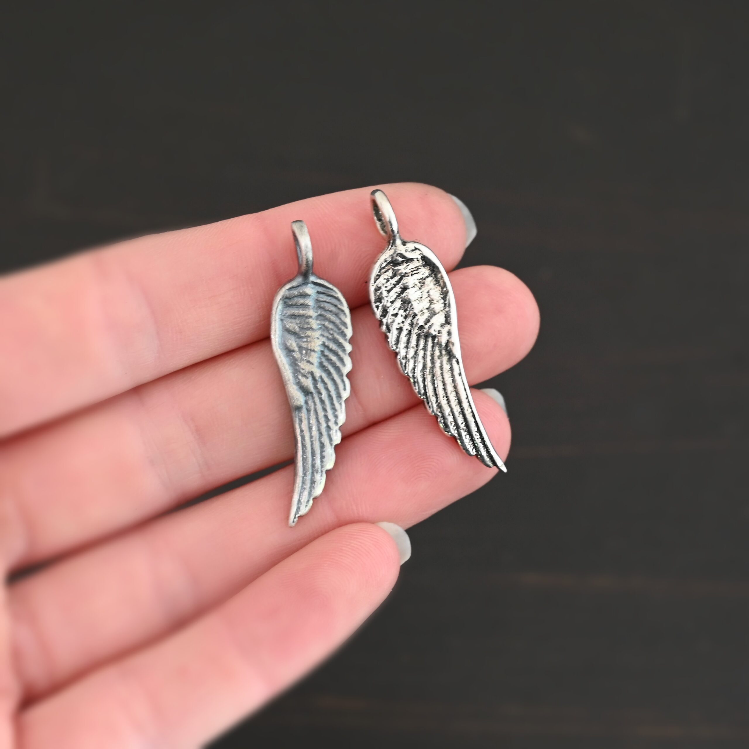 Silver Angel Wing charm oxidized & shiny charm shown in hand