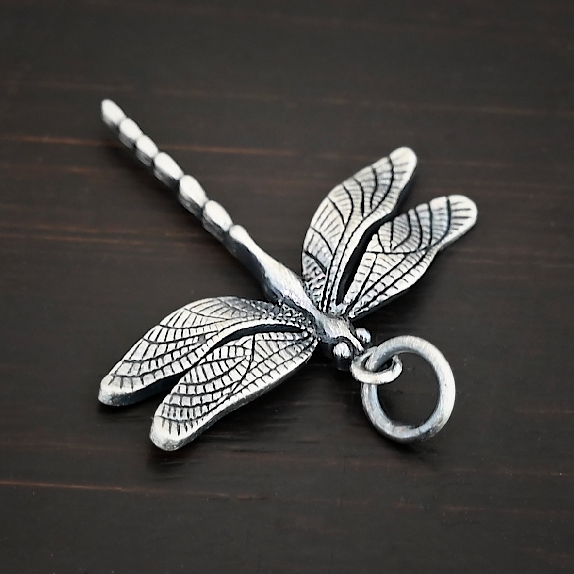 Silver Dragonfly charm oxidized charm shown on dark background