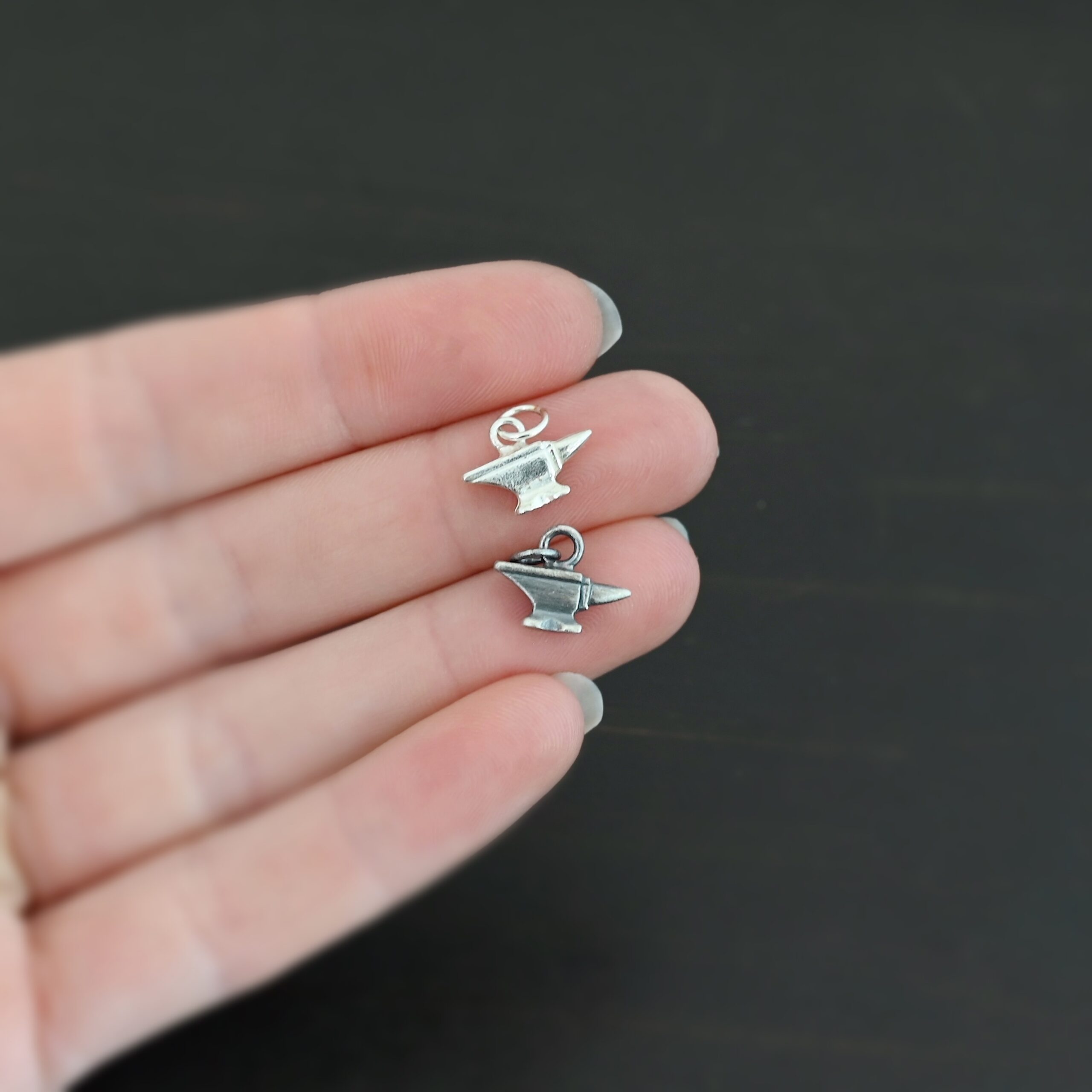 Silver anvil charm shiny & oxidized shown in hand