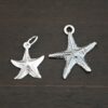 Silver star fish charms shown on dark background