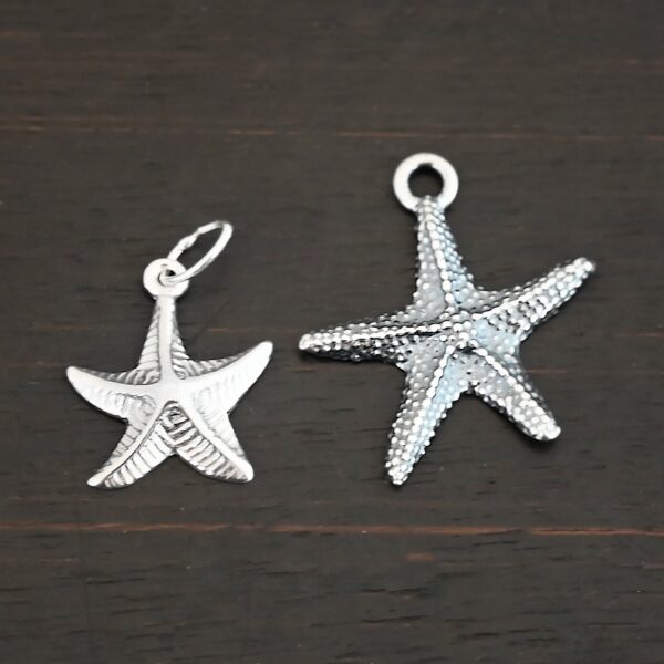 Silver star fish charms shown on dark background