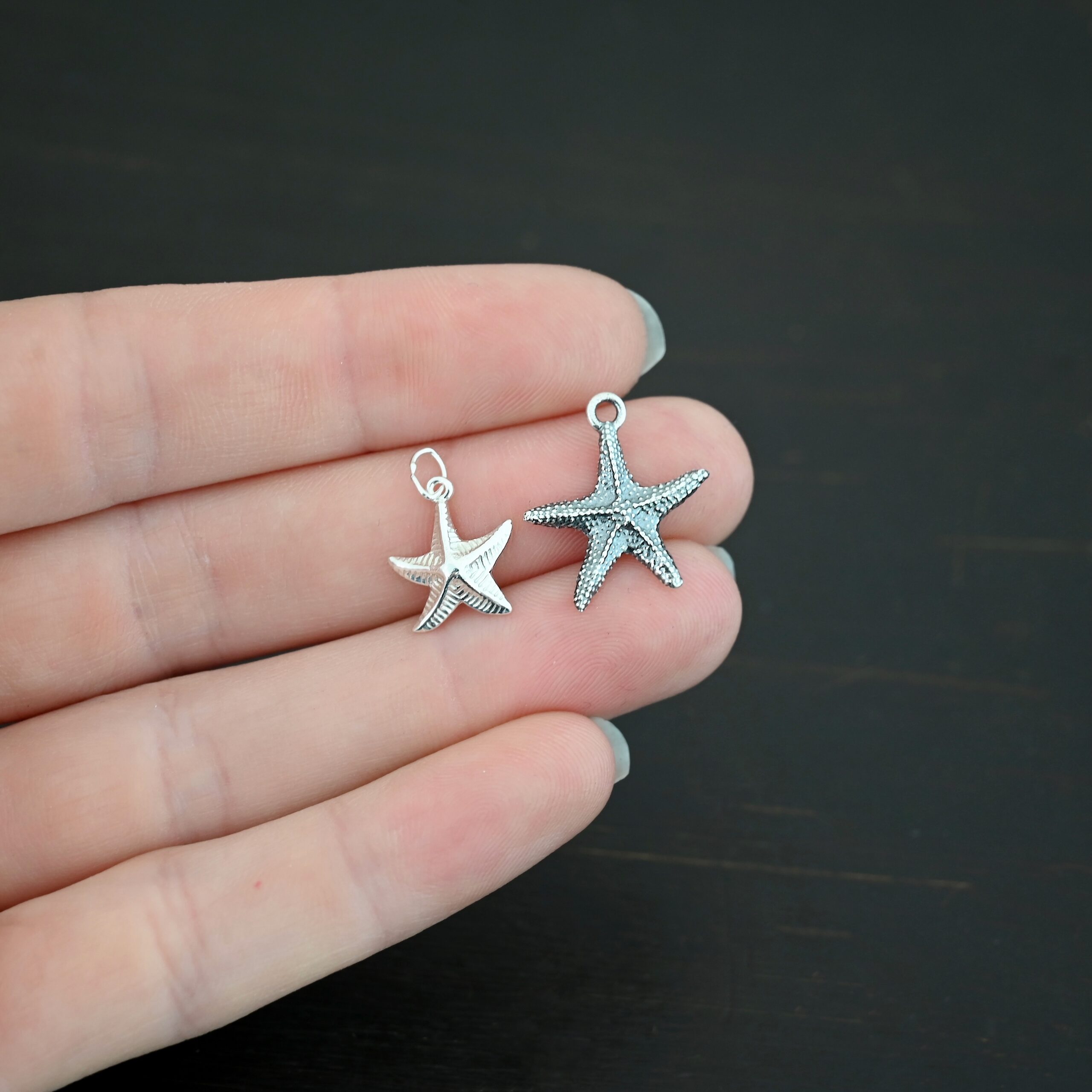 Silver star fish charms shown in hand