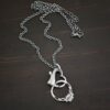 Silver heart charm oxidized pendant necklace shown on dark background