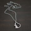 Silver heart charm oxidized pendant necklace shown on dark background