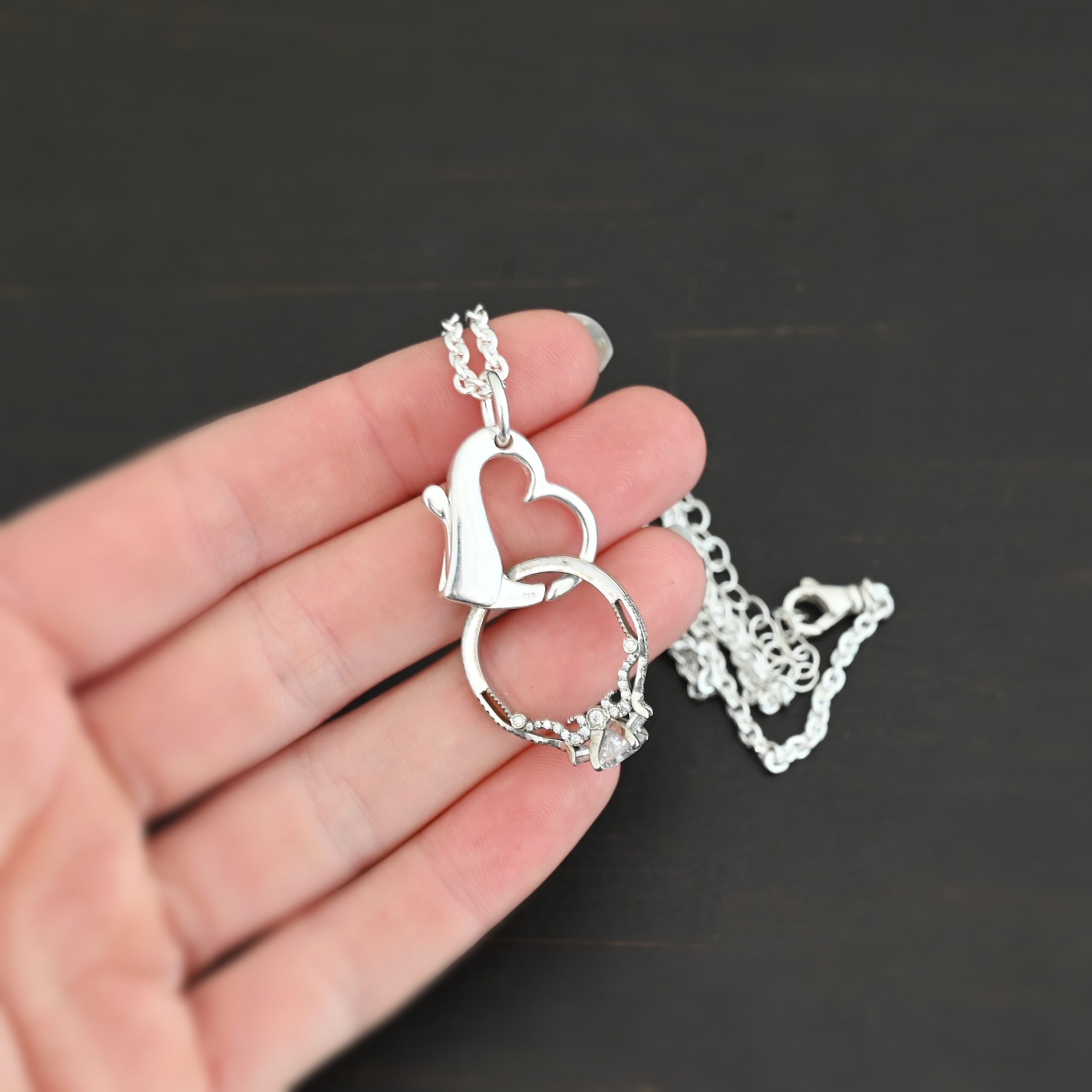 Silver heart charm shiny pendant necklace shown in hand