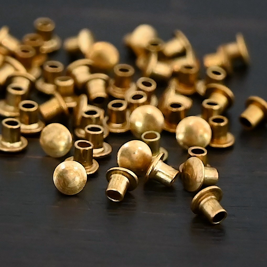 1/16x1/16 Brass Rivets shown on dark background