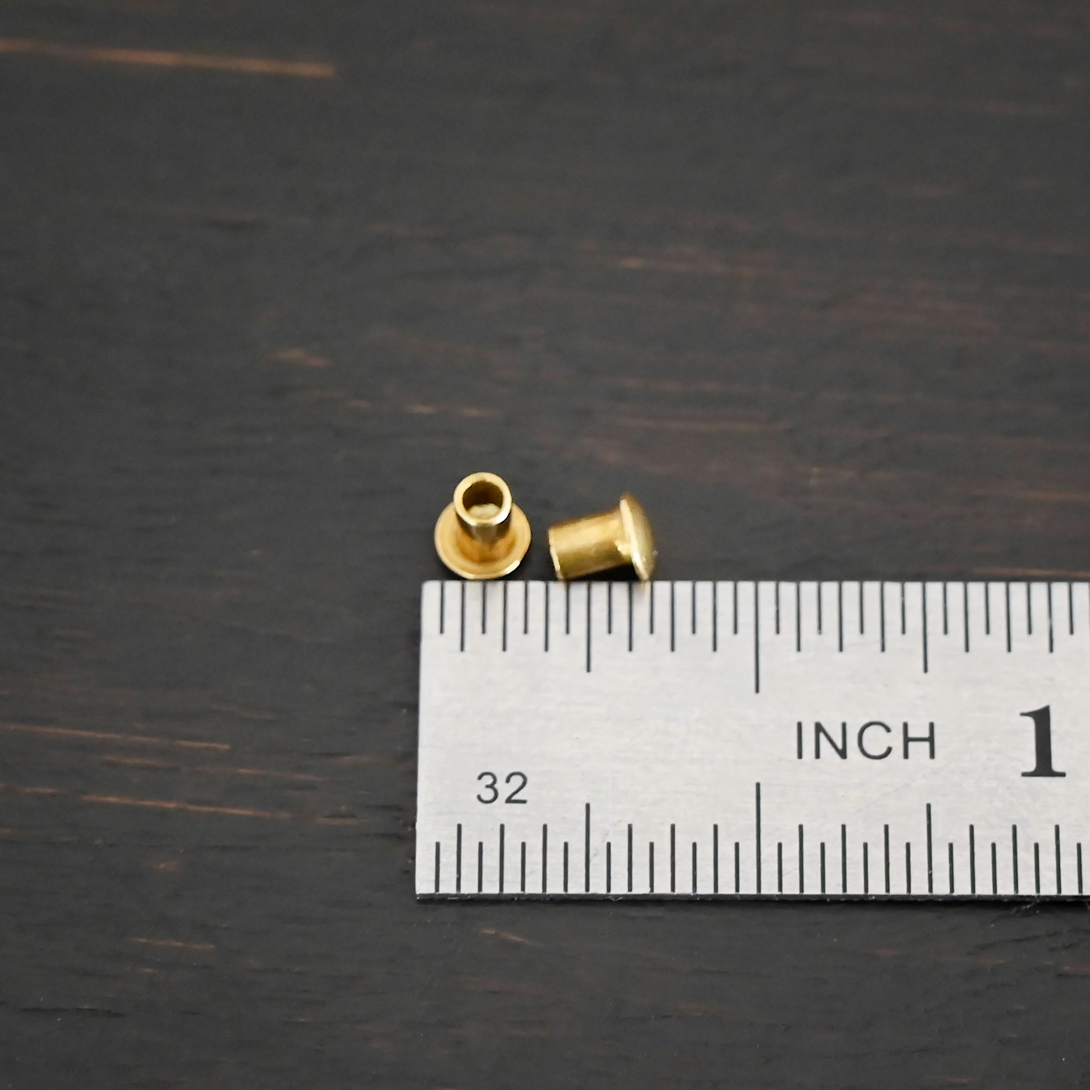 3/32x1/8 Brass Rivets shown by ruler