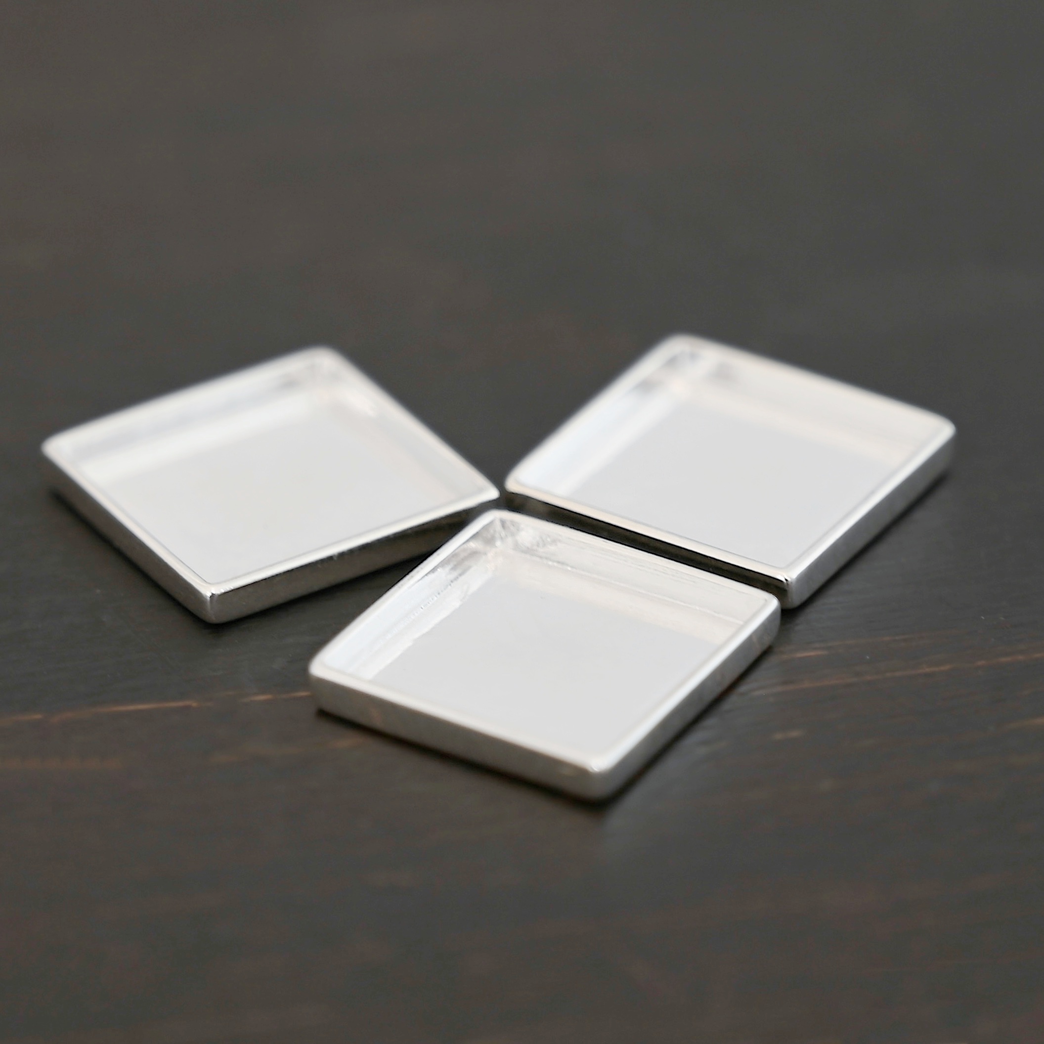 Thick square bezel cups - shiny Thick square bezel cups - shiny shown on dark background