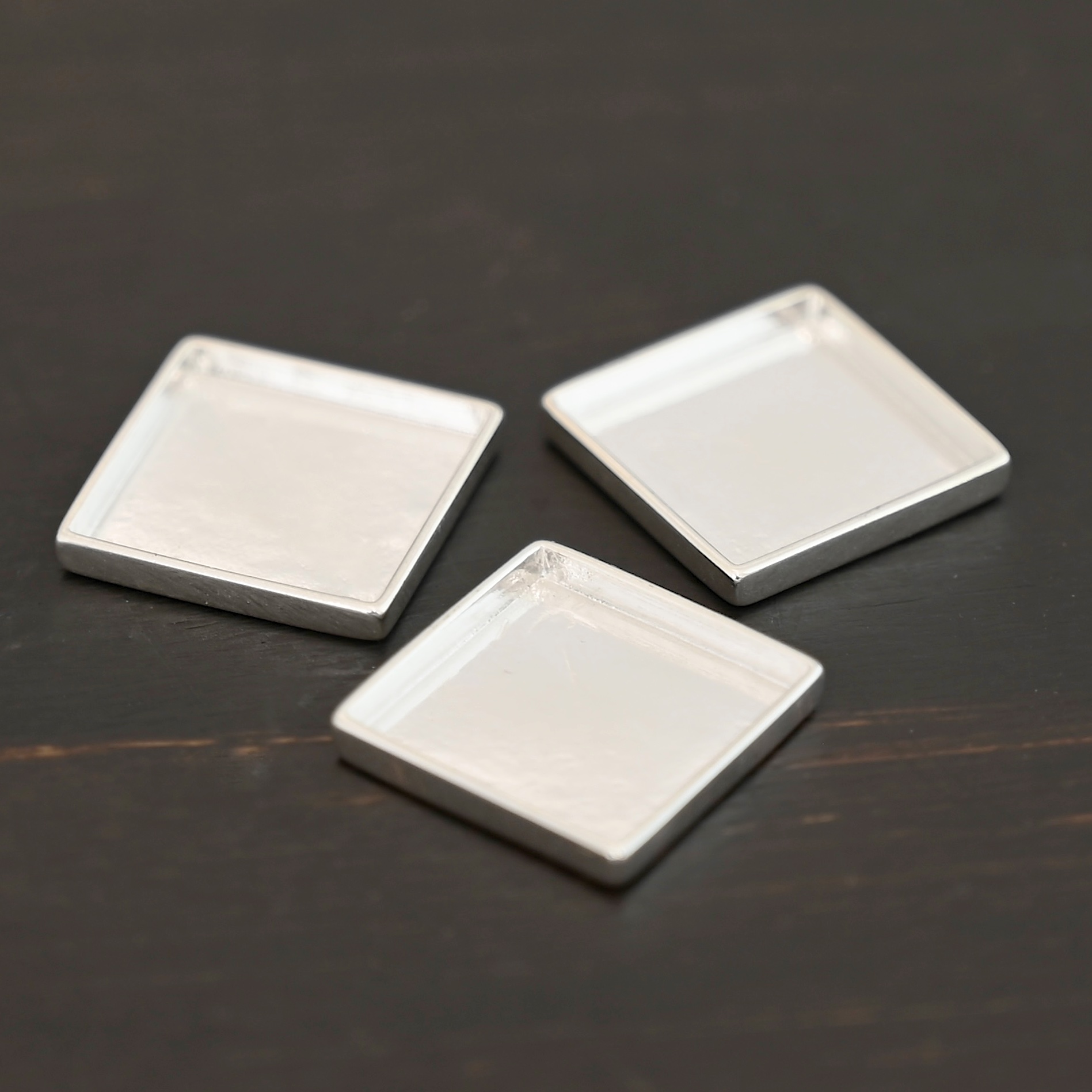 Thick square bezel cups - shiny Thick square bezel cups - shiny shown on dark background