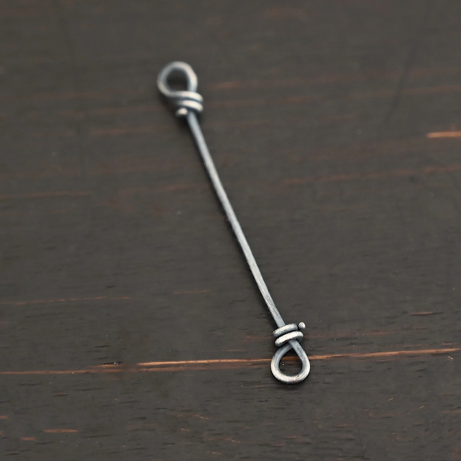 Stick Loop Finding - oxidized Stick Loop Finding - oxidized shown on dark background