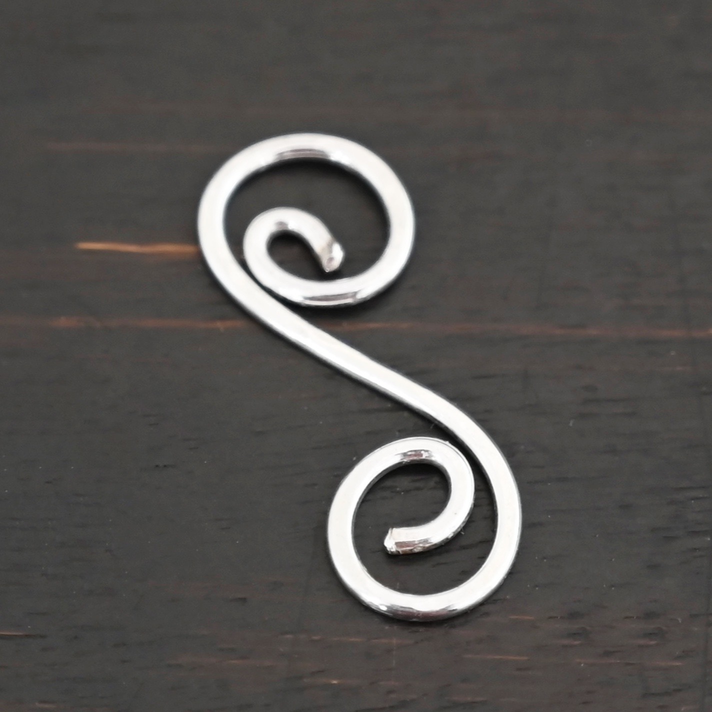 Hammered Swirl Finding - shiny S Shaped Finding - shiny shown on dark background