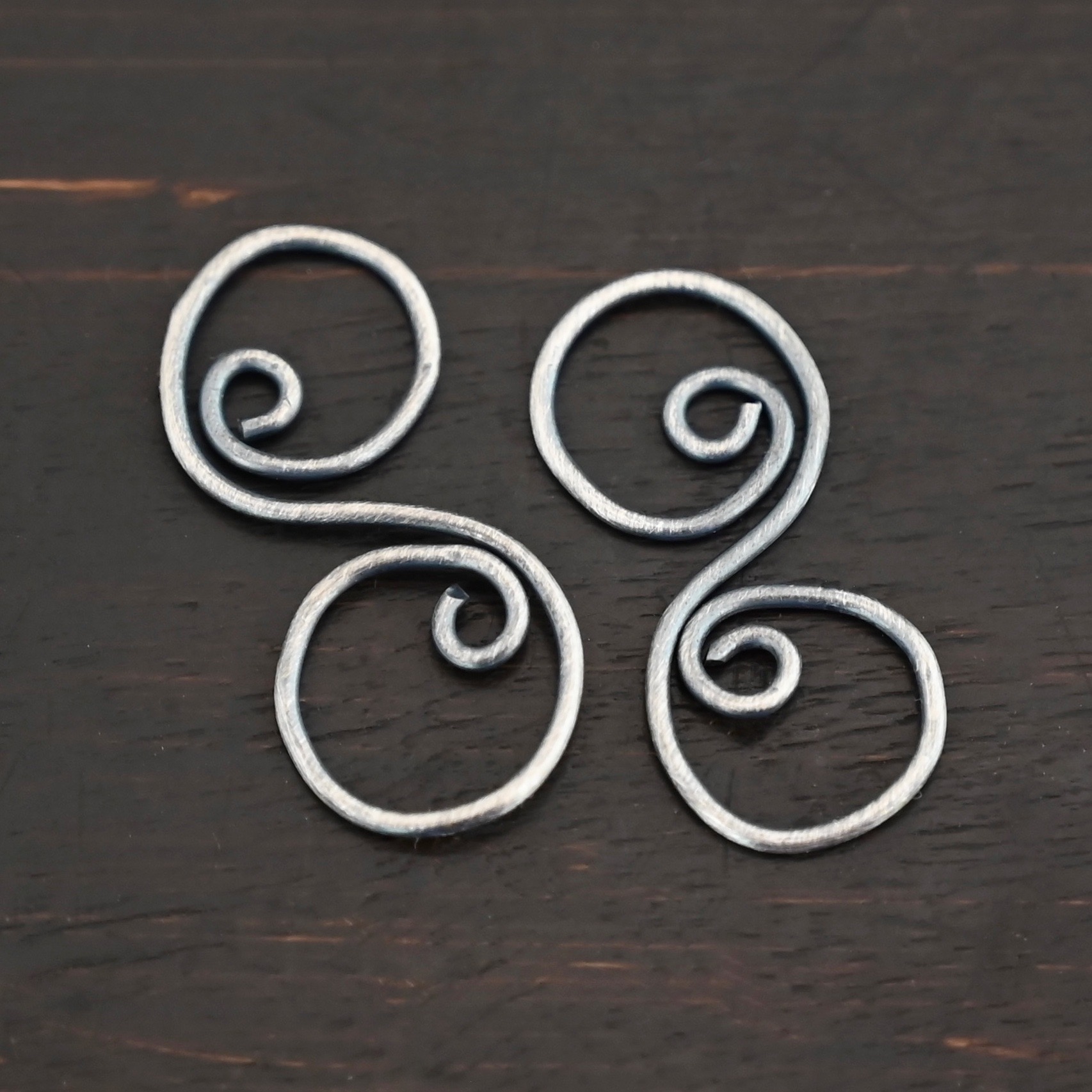 Paired S Shaped Finding - oxidized smooth shown on dark background