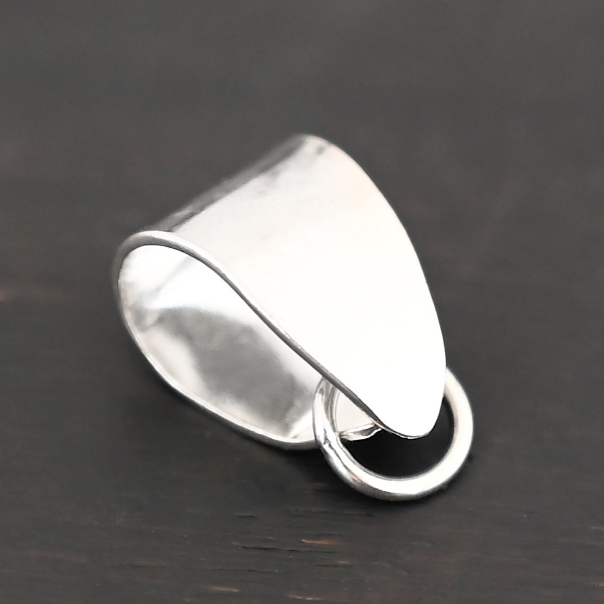 Handmade Pinch Bail - shiny soldered jump ring shown on dark background