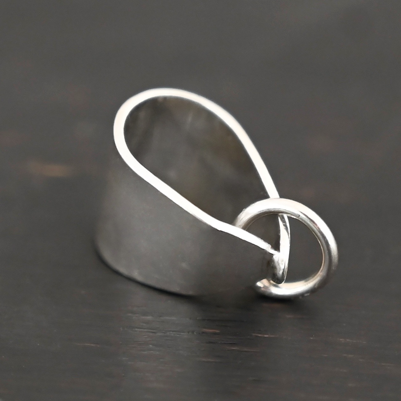 Handmade Pinch Bail - shiny soldered jump ring shown on dark background
