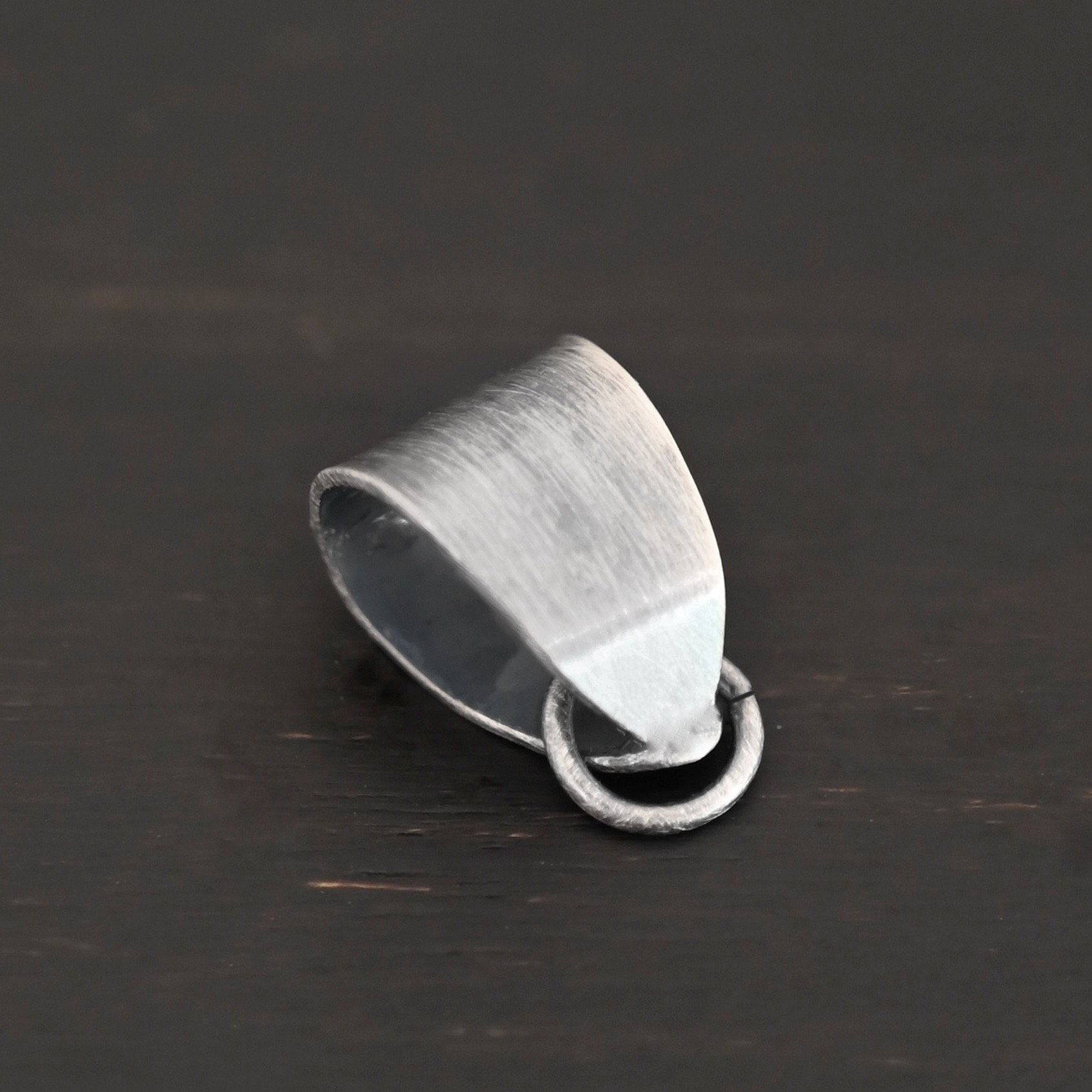 Handmade Pinch Bail - oxidized open jump ring shown on dark background