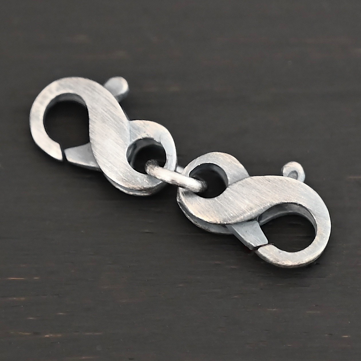 Faith double figure 8 clasp - oxidized shown on dark background