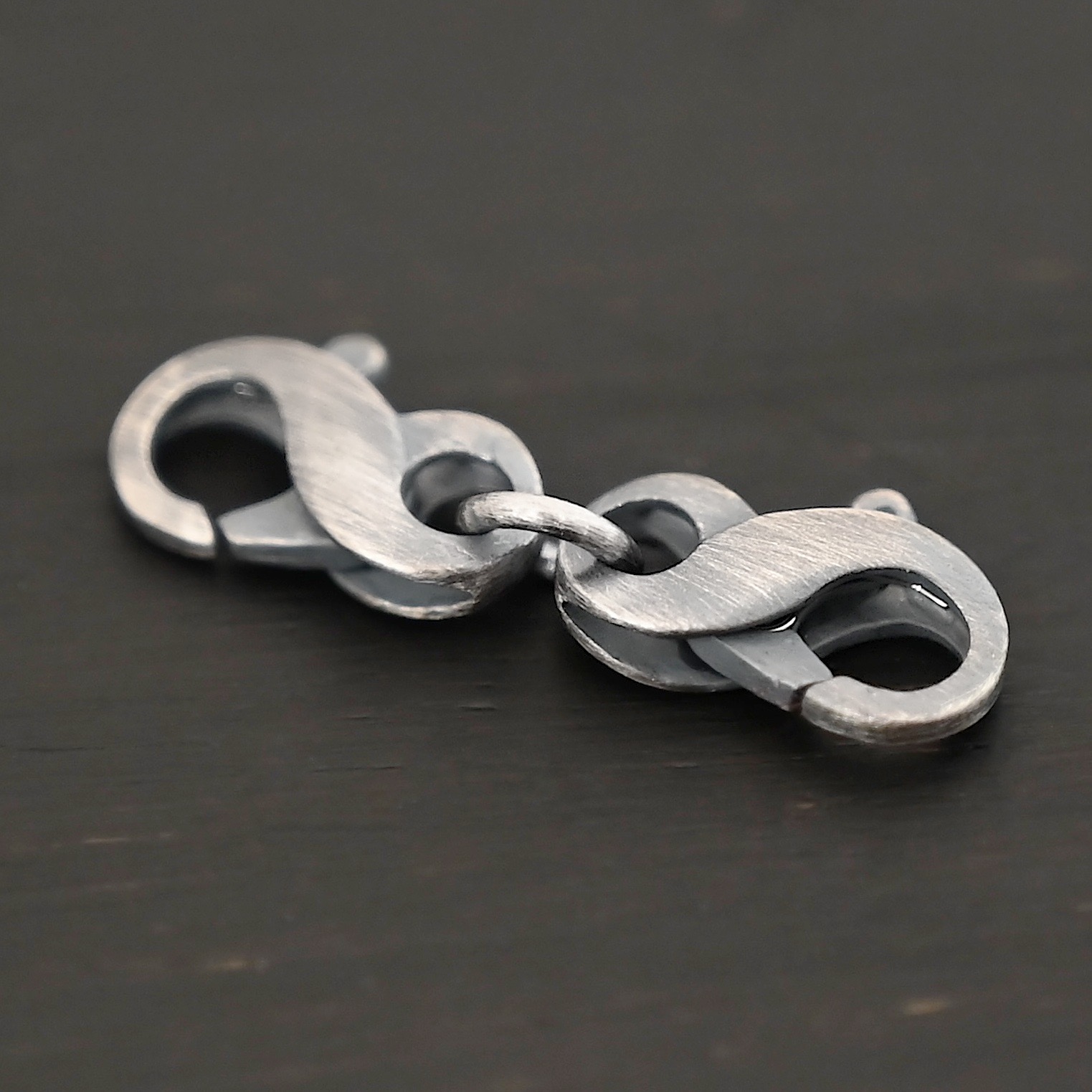 Faith double figure 8 clasp - oxidized shown on dark background