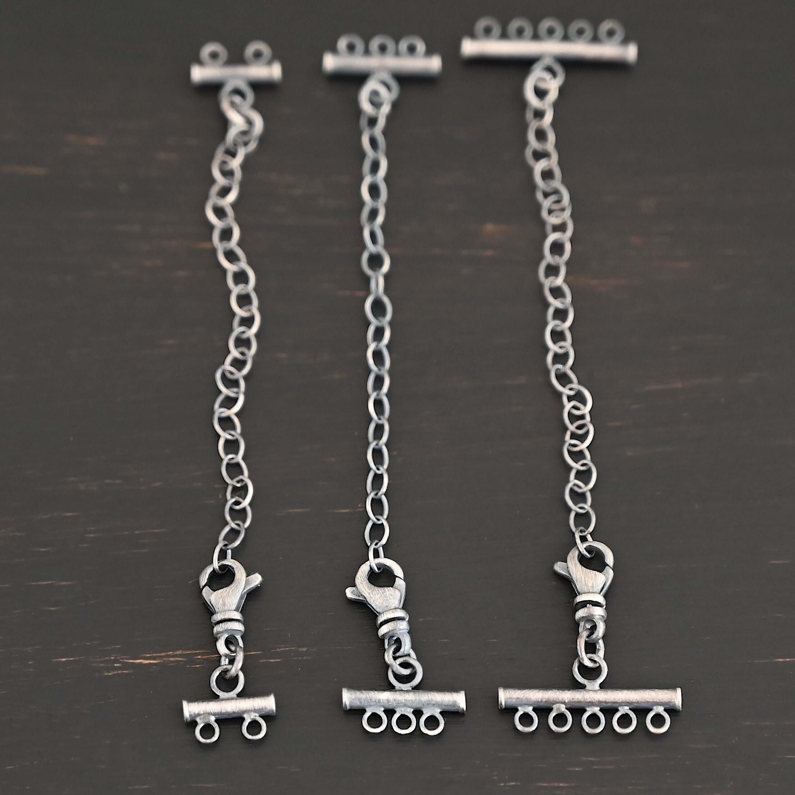 Matthew multistrand clasp - oxidized Matthew multistrand clasp - oxidized shown on dark background