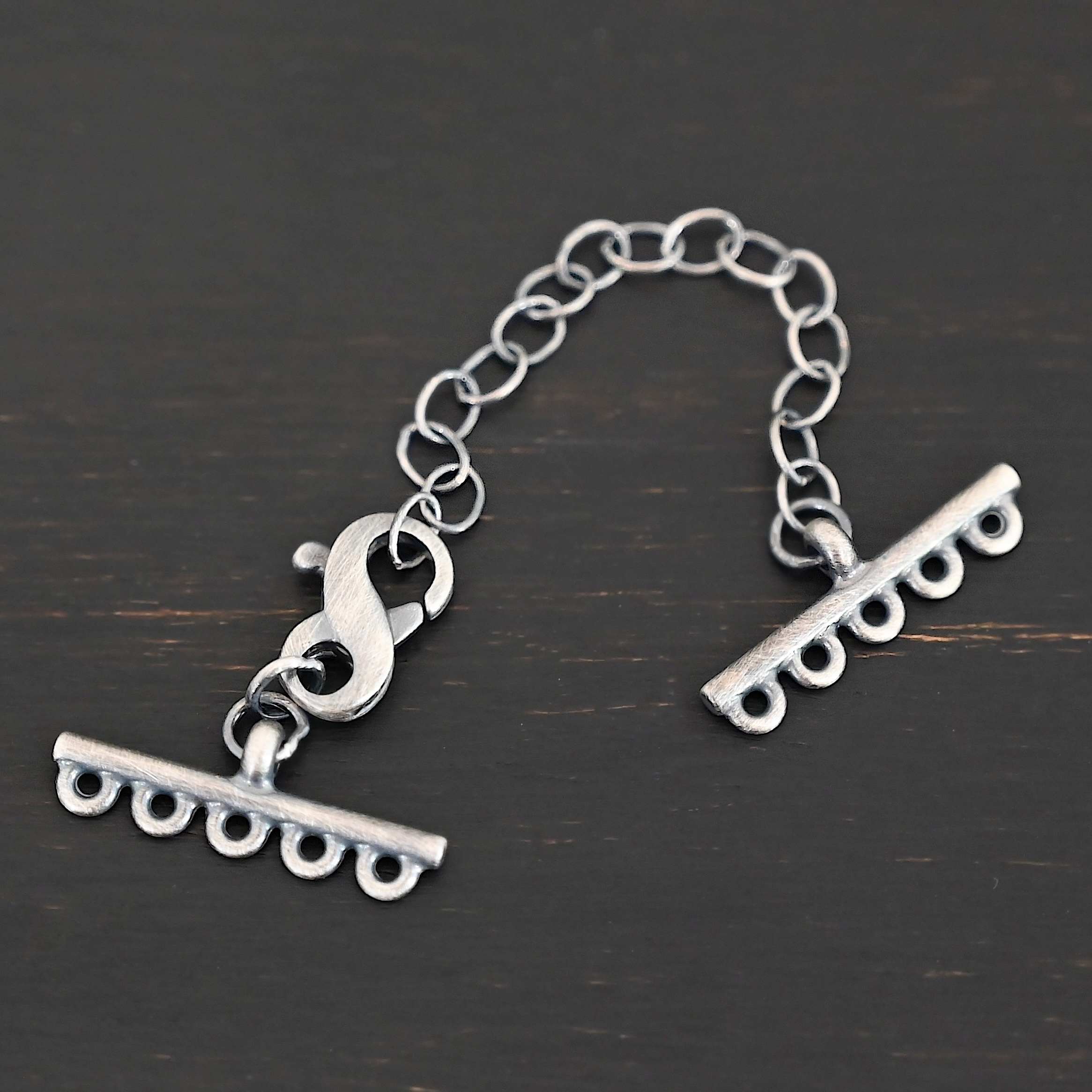 Max multistrand clasp - oxidized 5 strand shown on dark background