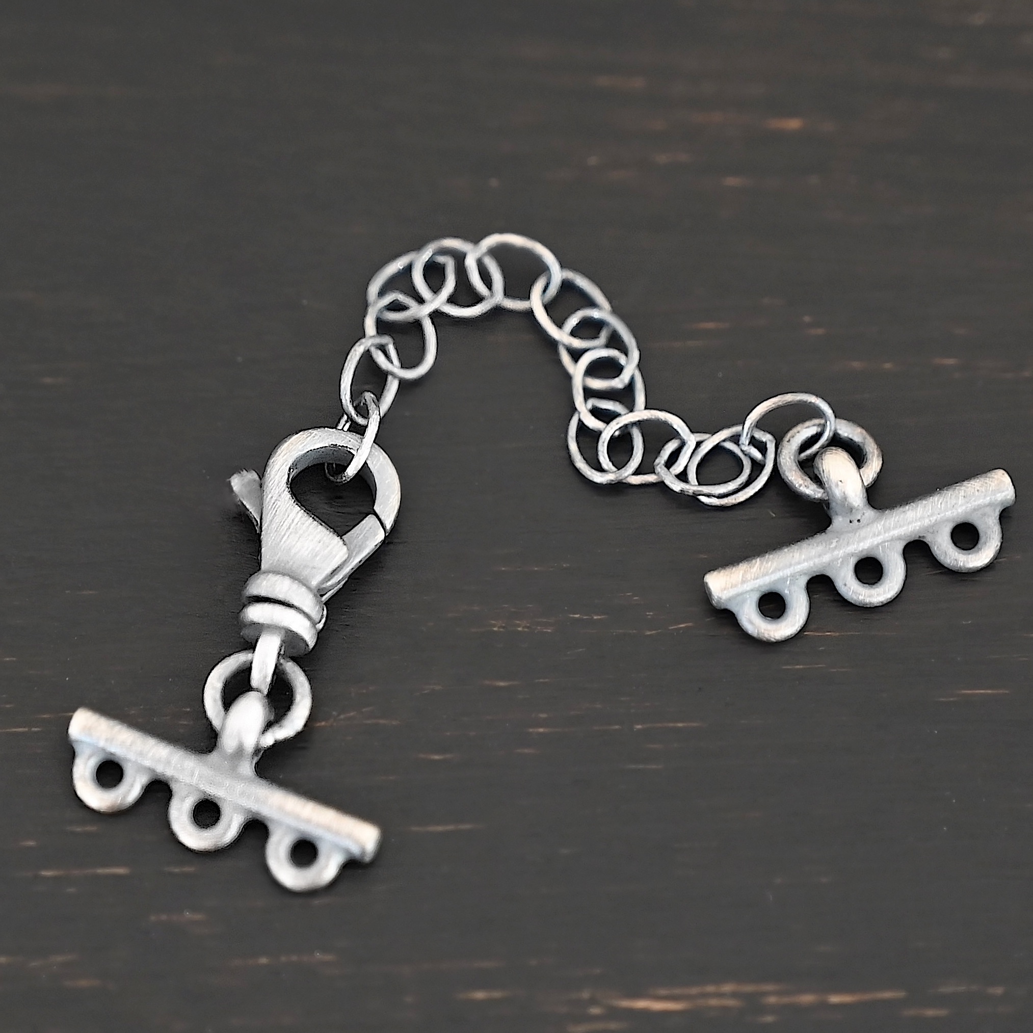 Myles multistrand clasp - oxidized 3 strand Myles multistrand clasp - oxidized 3 strand shown on dark background