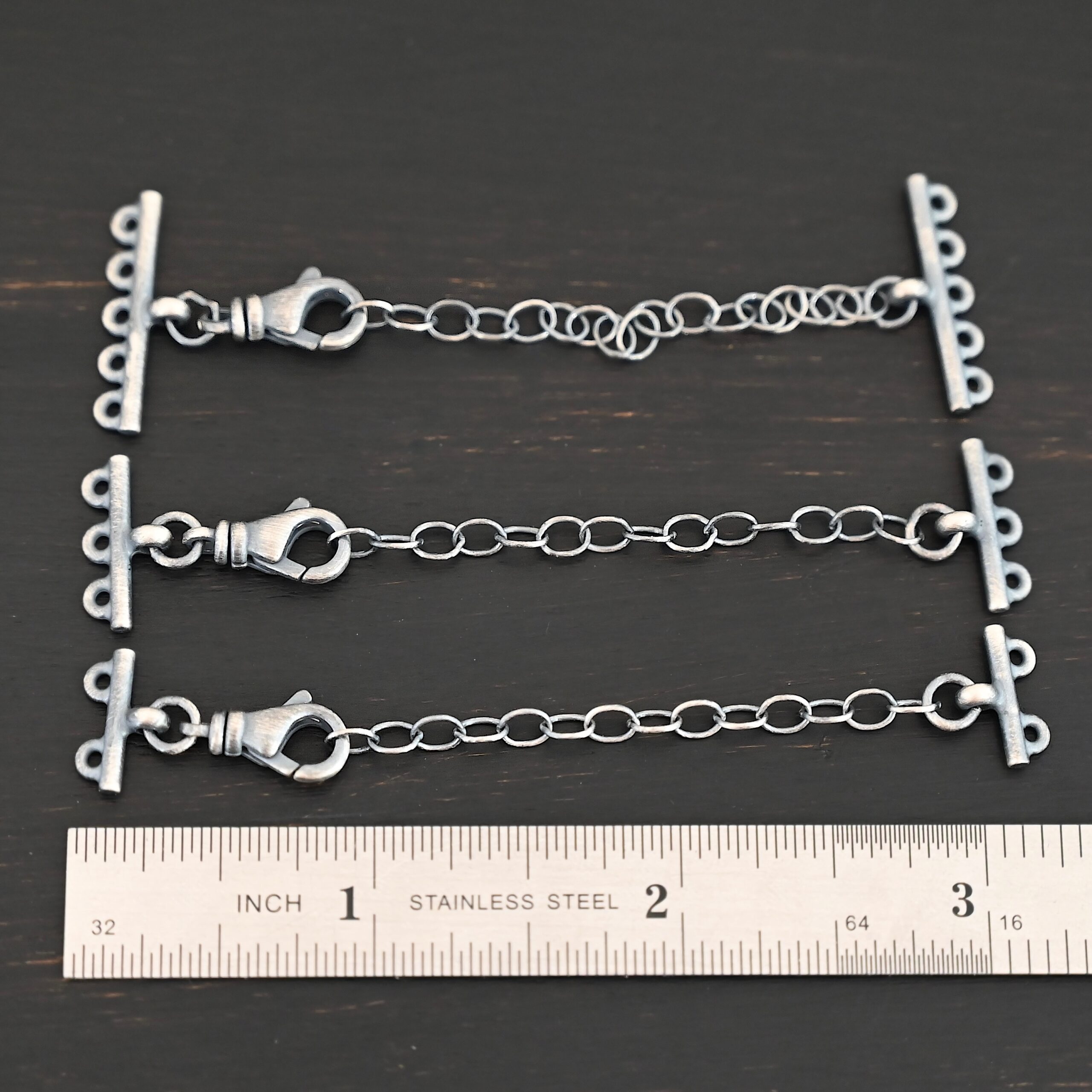Myles multistrand clasp - oxidized Myles multistrand clasp - oxidized shown by ruler