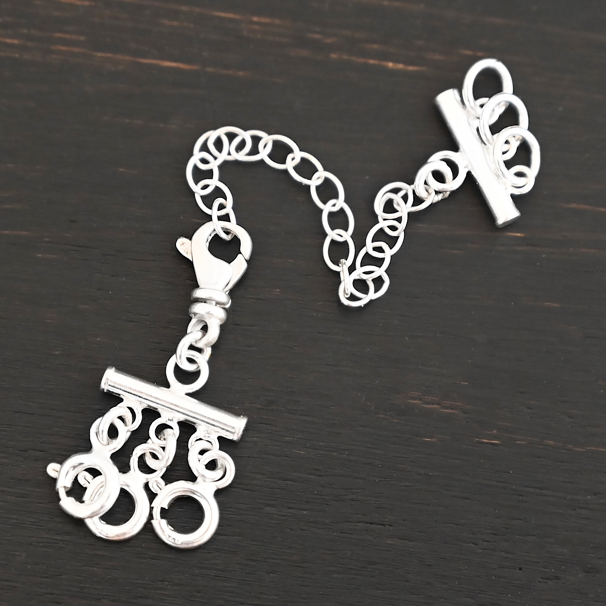 Matthew Multi strand necklace extender - shiny 3 strand shown on dark background