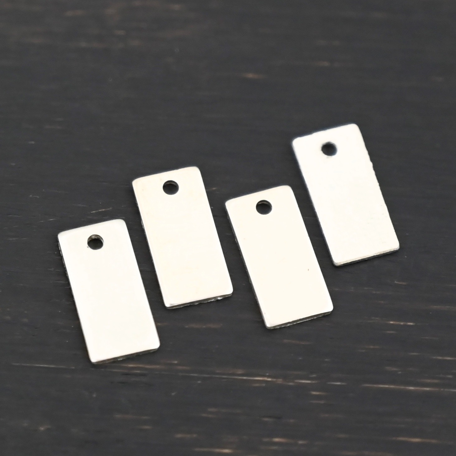 Sterling Silver small rectangle blank - shiny smooth 1 hole shown on dark background