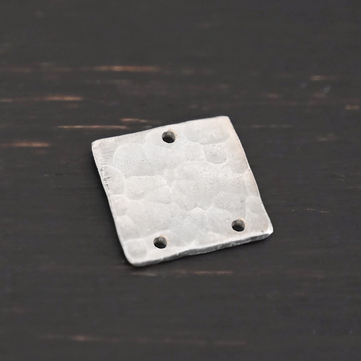 Hammered Square - shiny 3 holes Hammered Square - shiny 3 holes shown in dark background