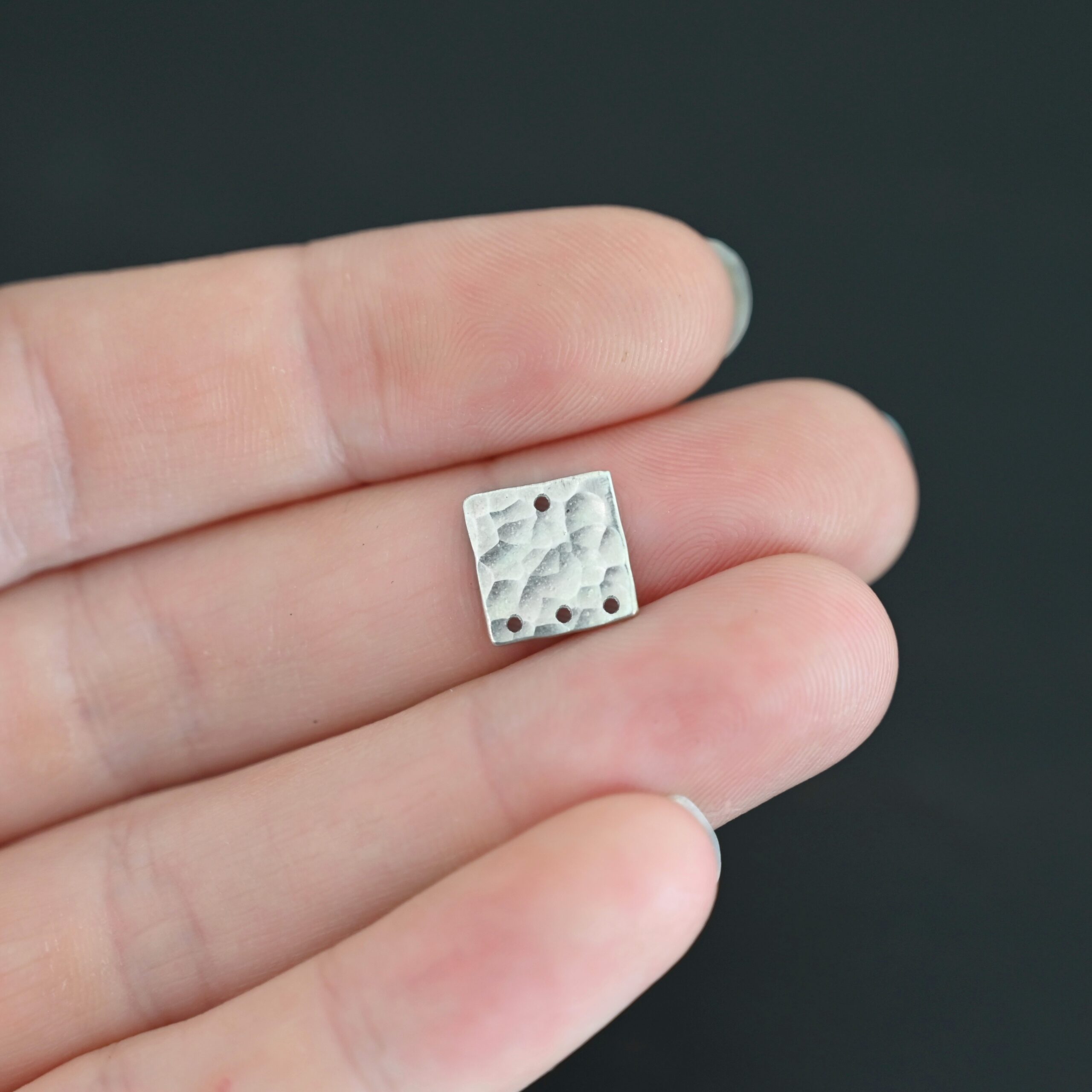Hammered Square - shiny 4 holes Hammered Square - shiny 4 holes shown in hand