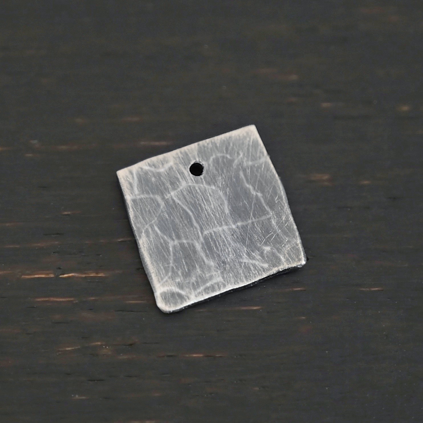 Hammered Square - oxidized 1 hole Hammered Square - oxidized 1 hole shown on dark background