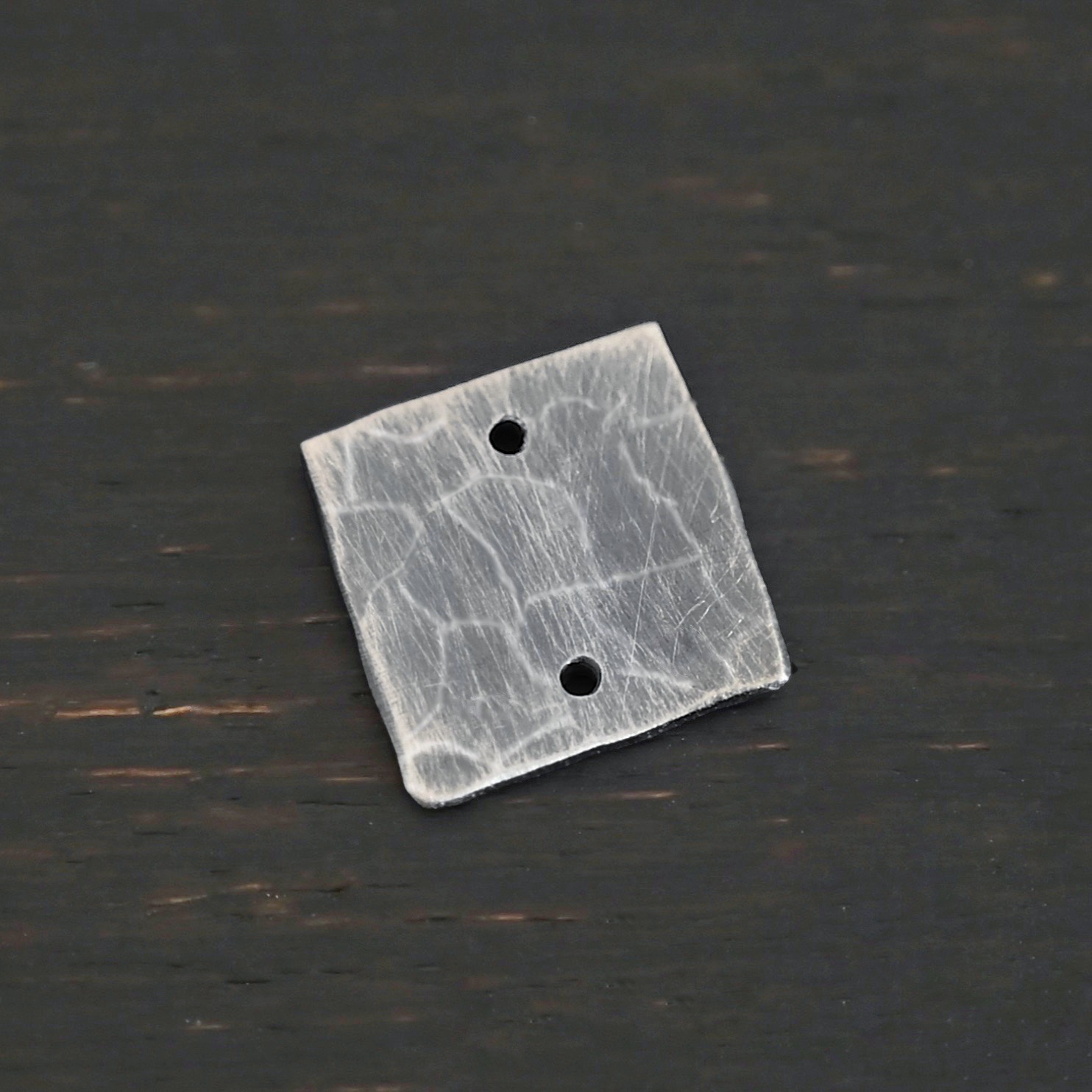Hammered Square - oxidized 2 holes Hammered Square - oxidized 2 holes shown on dark background