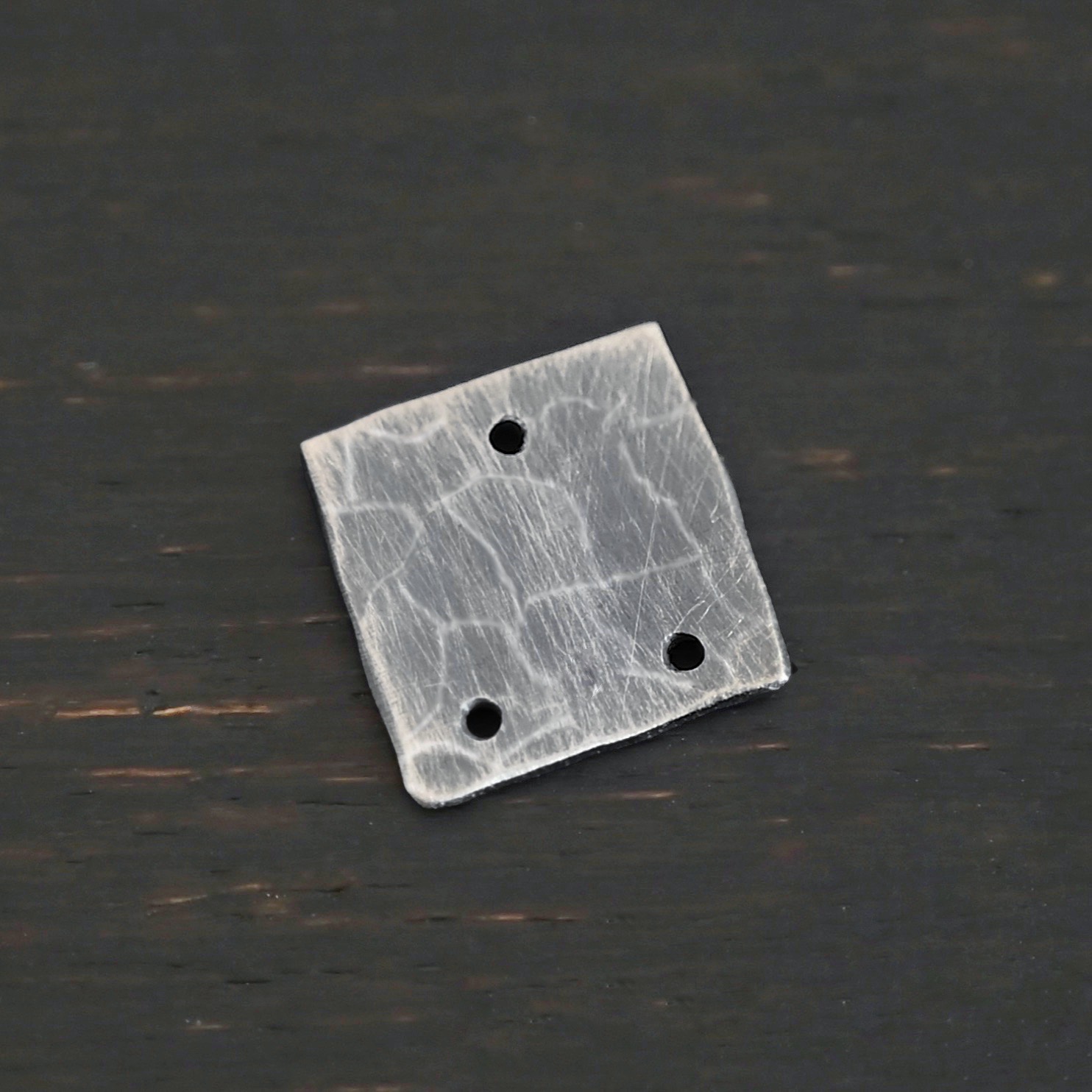 Hammered Square - oxidized 3 holes Hammered Square - oxidized 3 holes shown on dark background