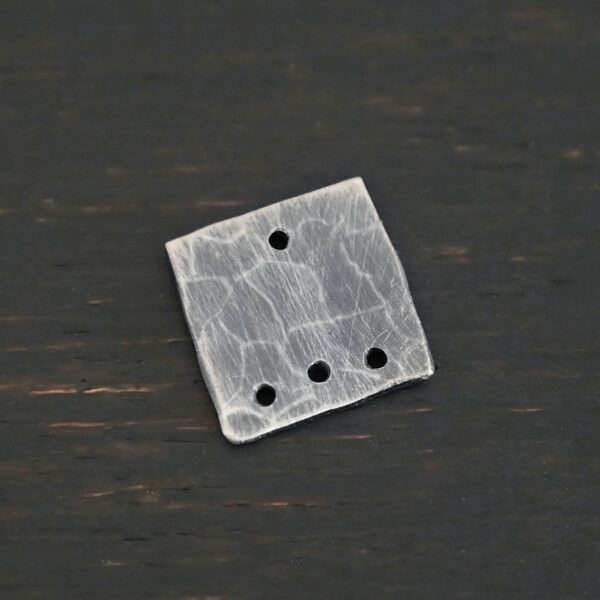 Hammered Square - oxidized 4 holes shown on dark background