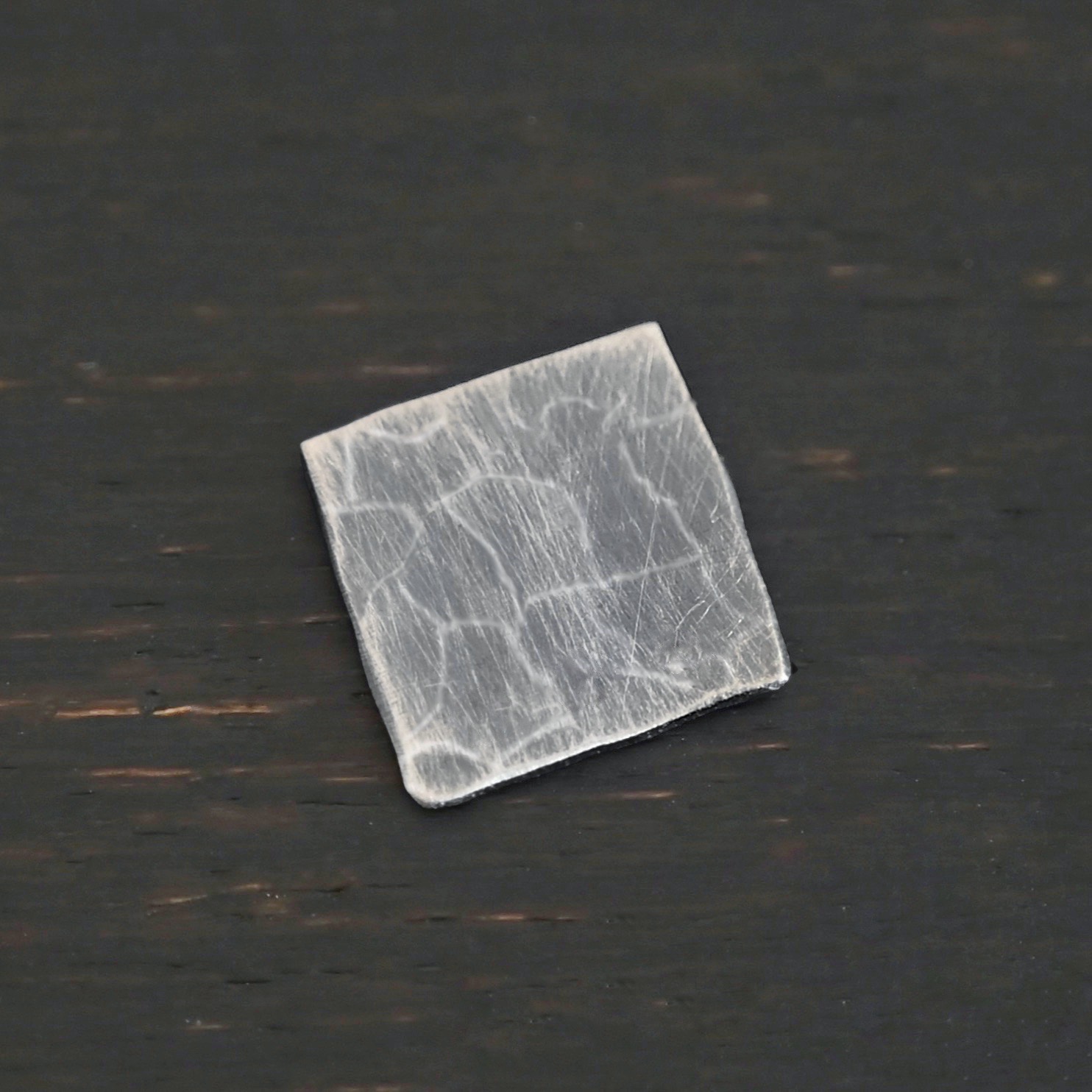 Hammered Square - oxidized 0 holes Hammered Square - oxidized 0 holes shown on dark background
