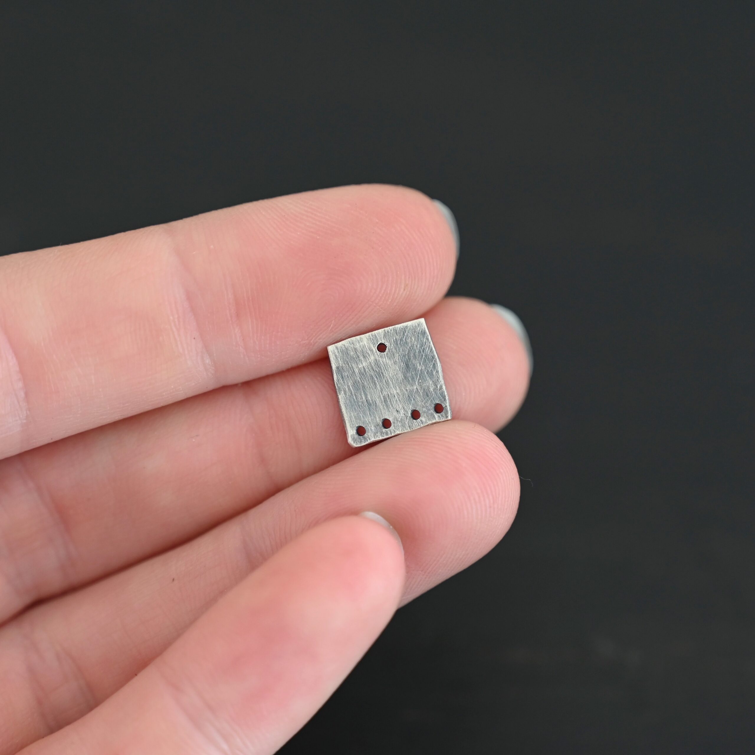 Hammered Square - oxidized 5 holes Hammered Square - oxidized 5 holes shown in hand