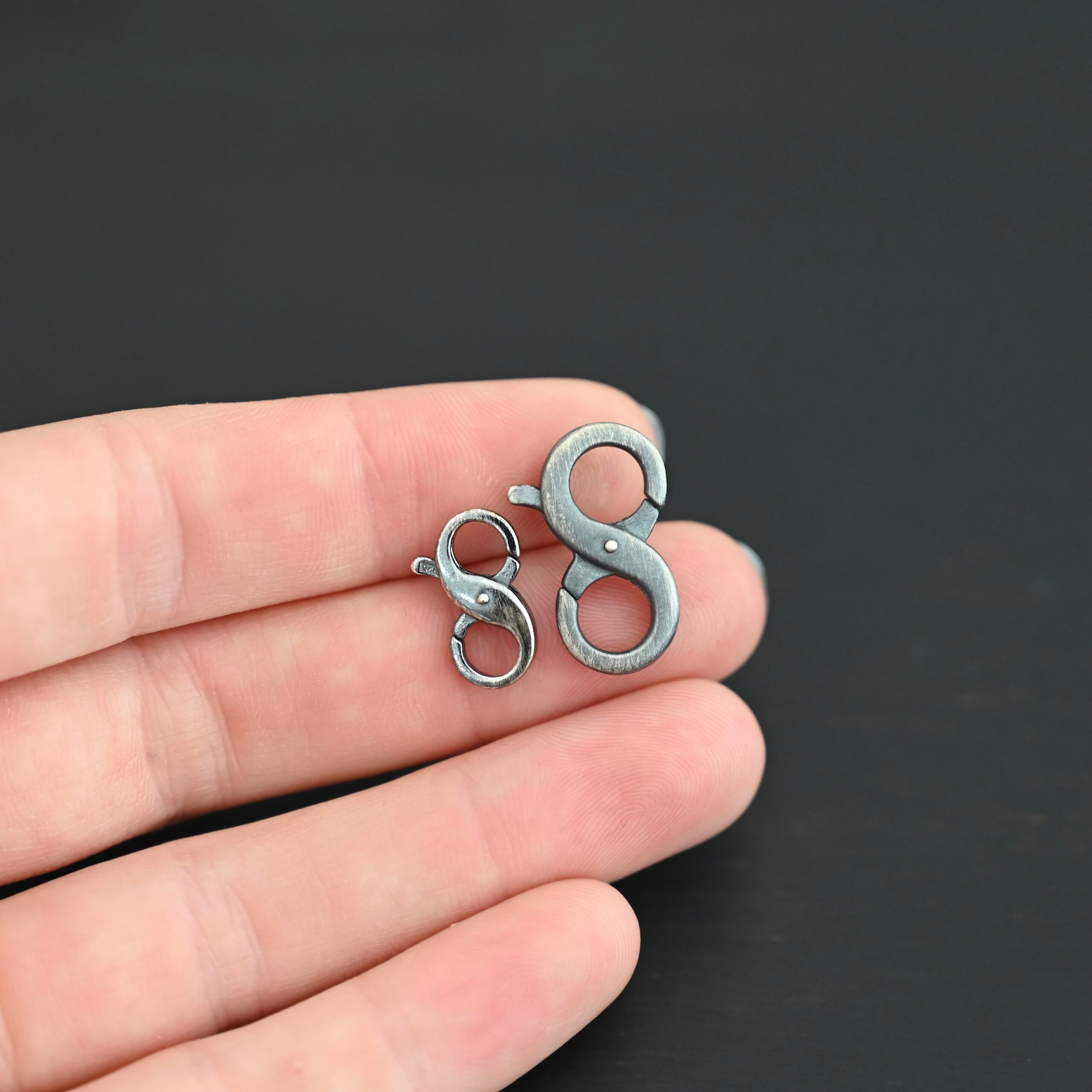 Daisy double lobster claw - oxidized shown in hand