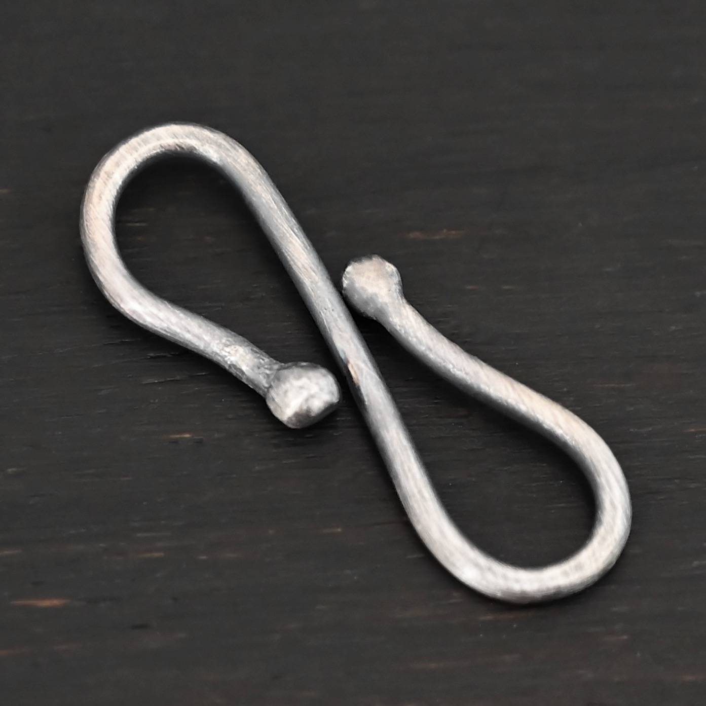 Saint S Clasp - oxidized shown on dark background