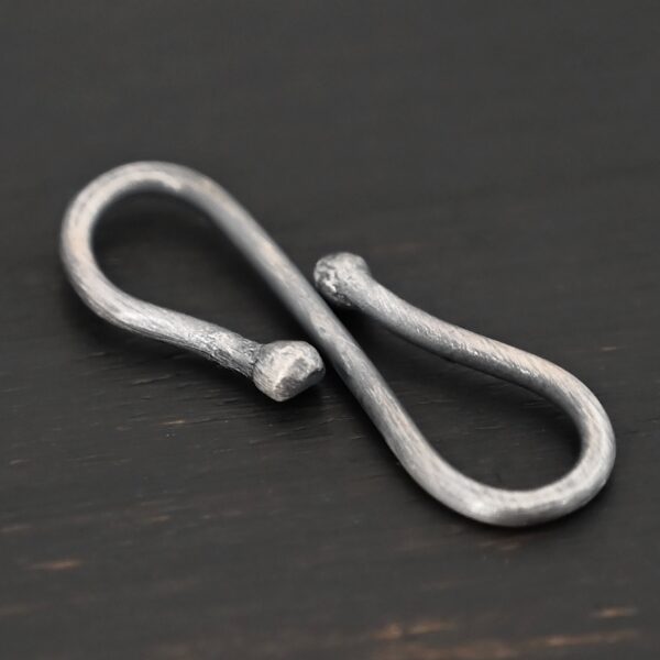 Saint S Clasp - oxidized shown on dark background