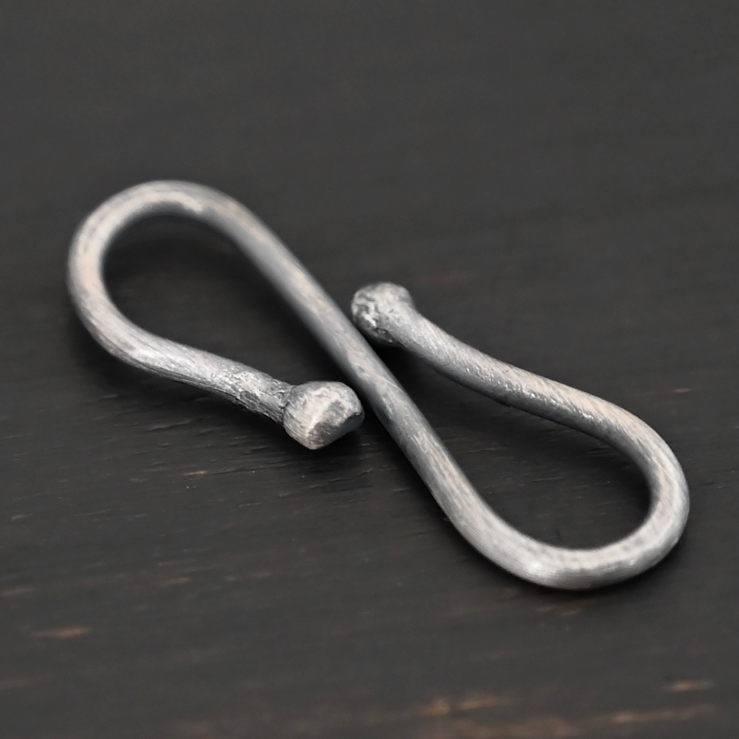 Saint S Clasp - oxidized shown on dark background