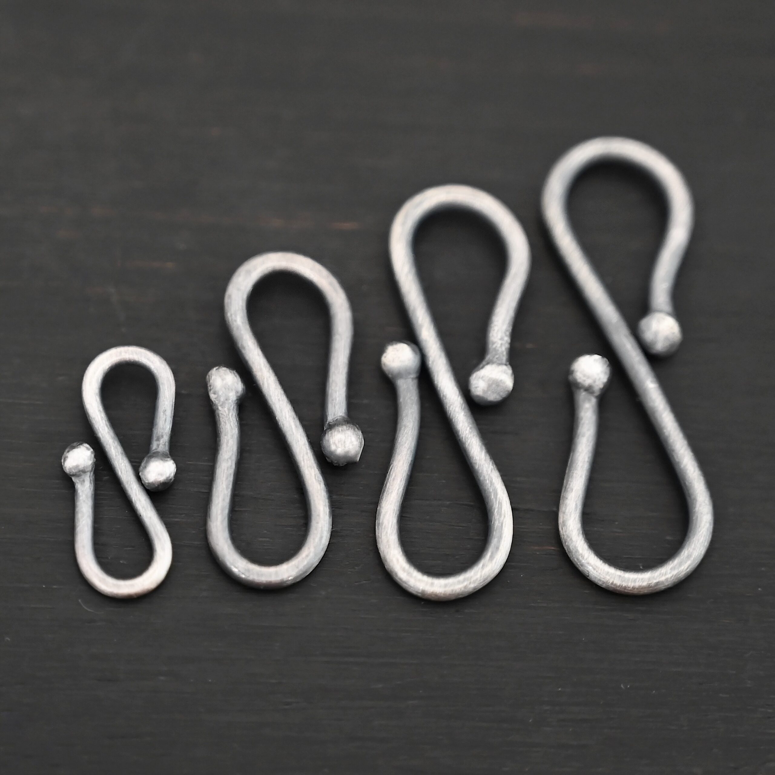 Saint S Clasp - oxidized shown on dark background