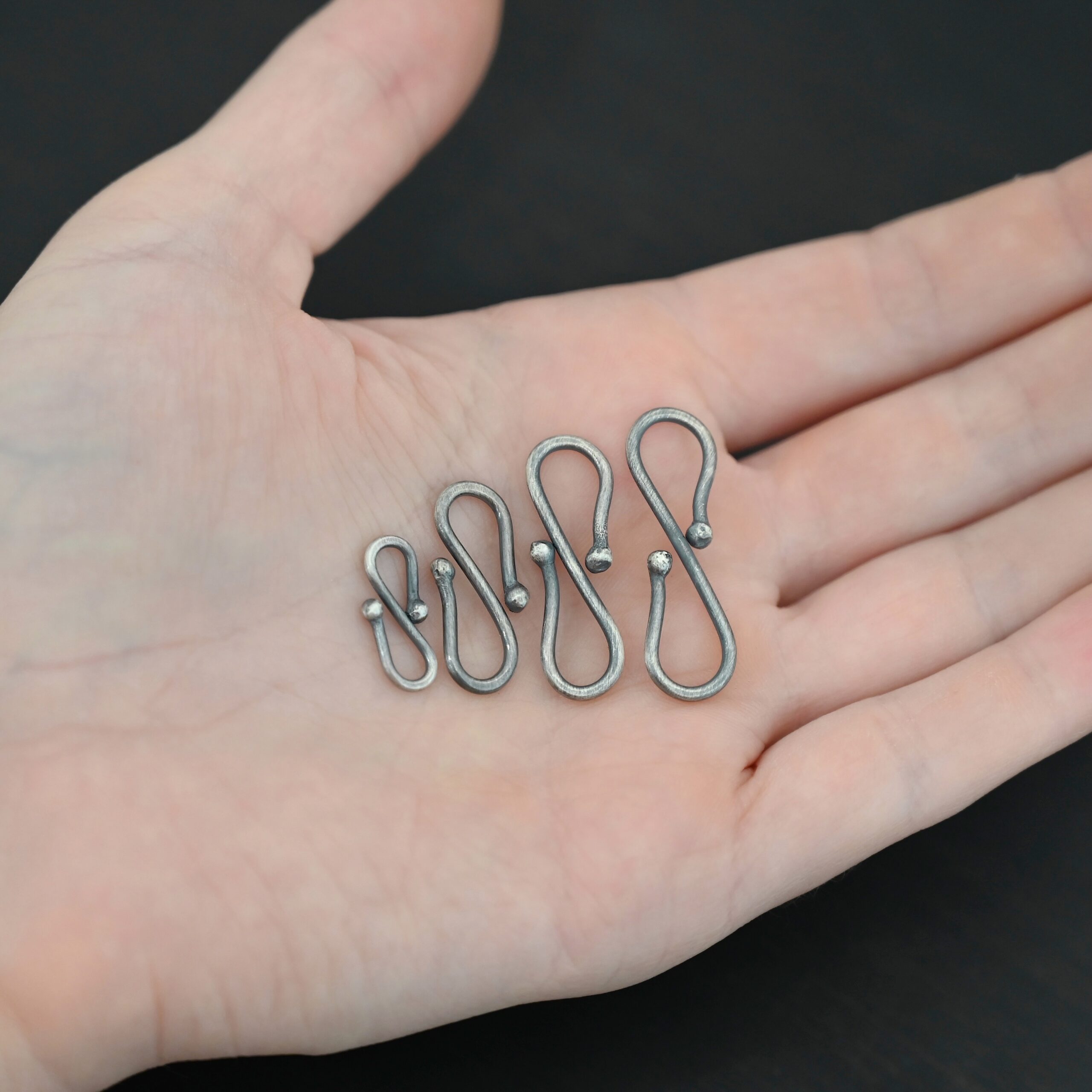 Saint S Clasp - oxidized shown in hand