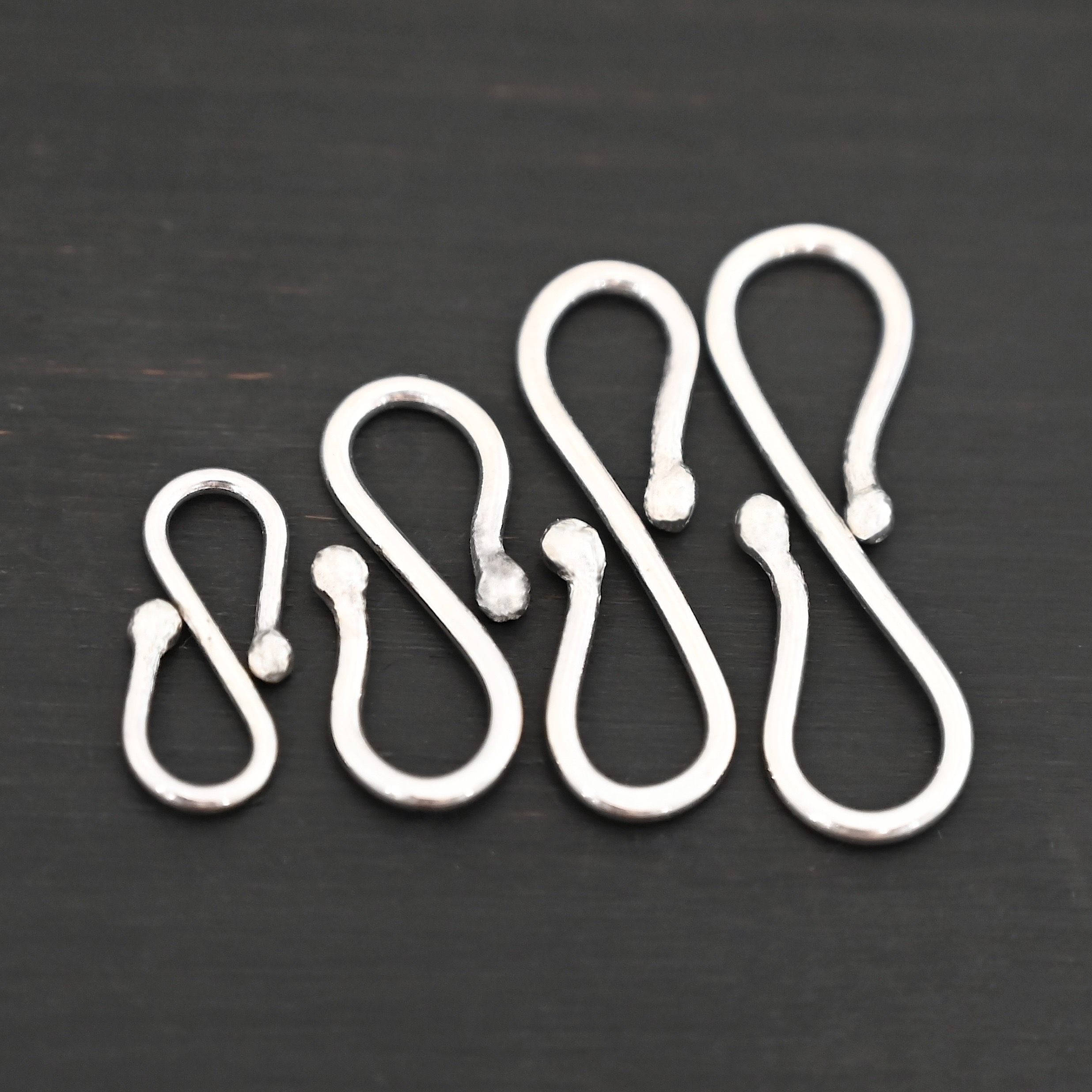 Saint S Clasp - shiny shown on dark background